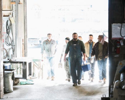 Workers entering door of workshop